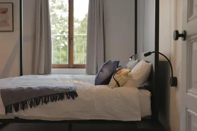 a bedroom with a bed with pillows and a window at MAISON KITOKO in Ghent