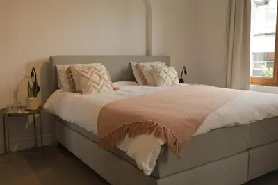 a bedroom with a bed with a blanket on it at MAISON KITOKO in Ghent