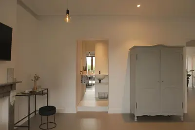 a living room with a white cabinet and a hallway at MAISON KITOKO in Ghent