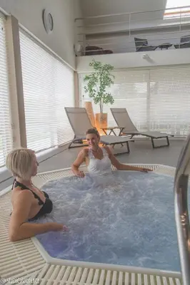 two women sitting in a jacuzzi in a hot tub at Lavendelhof luxe wellnesshouse in Zottegem