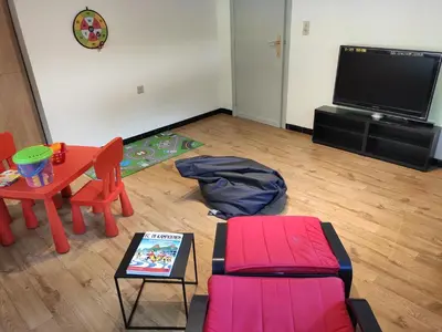 a living room with a table and a tv at Villa Chill in Scherpenheuvel-Zichem