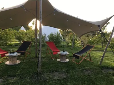 a group of chairs and a table under an umbrella at Landgoed Omorika in Ravels