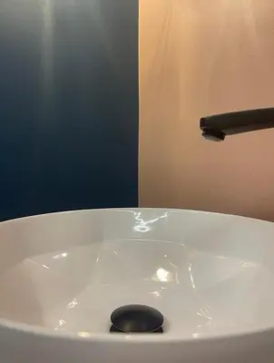 a black spoon sitting on top of a white sink at Royal Diamond Apartment @ Central Station in Antwerp