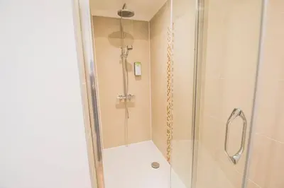 a bathroom with a shower with a glass door at Smart Appart - Gare Du Midi in Brussels