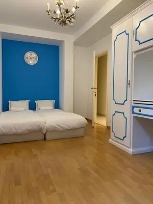 a room with two beds and a blue wall at lovely two bedroom apartment with free parking in Antwerp