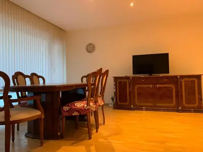 a dining room with a table and chairs and a television at lovely two bedroom apartment with free parking in Antwerp