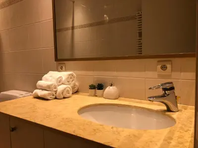 a bathroom sink with towels and a mirror at lovely two bedroom apartment with free parking in Antwerp