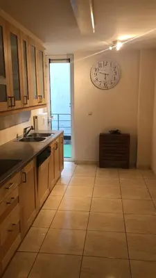 a large kitchen with a clock on the wall at lovely two bedroom apartment with free parking in Antwerp