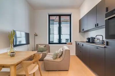 a kitchen with a table and chairs and a dining room at Design Studio Gent nabij station, musea &centrum in Ghent