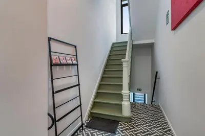 a staircase in a house with a green stair case at Design Studio Gent nabij station, musea &centrum in Ghent