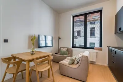 a kitchen and living room with a table and chairs at Design Studio Gent nabij station, musea &centrum in Ghent