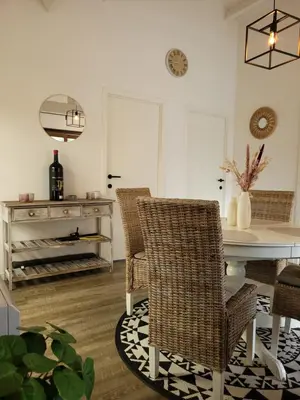 a dining room with wicker chairs and a table at Rustig gelegen chalet Kapeki met tuin aan het water in Geel