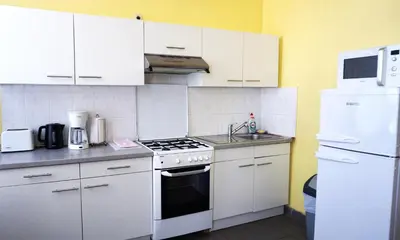 a kitchen with white cabinets and a stove top oven at Apartments Marco Polo Midi in Brussels