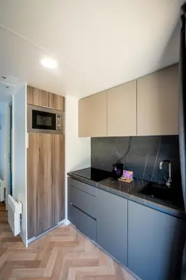 a kitchen with white cabinets and a black counter top at Urban Gardens Gent in Ghent