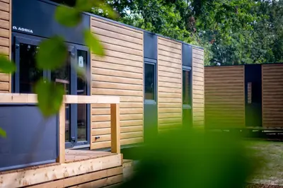 a house with wooden siding and green doors at Urban Gardens Gent in Ghent
