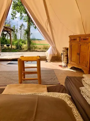a room with two beds and a dresser in a tent at Cowcooning / Family tents in Huldenberg