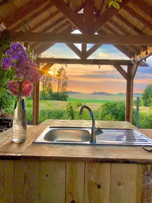 a kitchen sink with a vase of flowers on a counter at Cowcooning / Family tents in Huldenberg