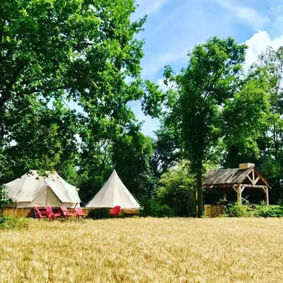 two tents and chairs in a field of hay at Cowcooning / Family tents in Huldenberg