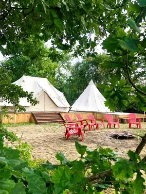 a group of red chairs and white tents at Cowcooning / Family tents in Huldenberg