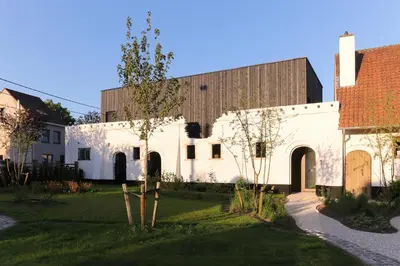 a large white building with a brown roof at HUIS19 Luxury apartments in Ghent