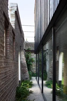 an alleyway between two brick buildings with windows at HUIS19 Luxury apartments in Ghent