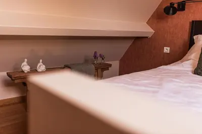 a bedroom with a bed and a table with a chair at B&B Maison Lize in Lievegem