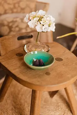 a table with a vase of flowers and a bowl of fruit at B&B Maison Lize in Lievegem