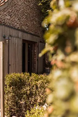a brick building with a window and a fence at B&B Maison Lize in Lievegem