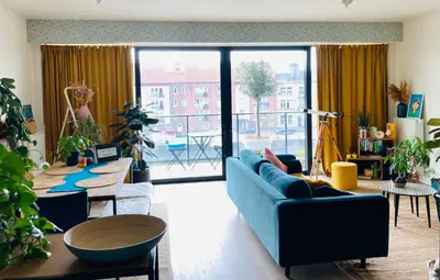 a living room with a blue couch and a table at Cozy two bedroom Apartment near city centre Gent in Ghent
