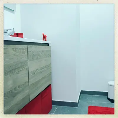 a kitchen with a counter top with a red cabinet at Cozy two bedroom Apartment near city centre Gent in Ghent