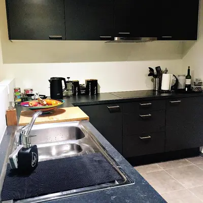 a kitchen with a stainless steel sink and black cabinets at Cozy two bedroom Apartment near city centre Gent in Ghent