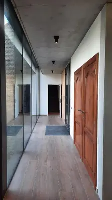 an empty hallway with wooden doors and a hallway with a hallway at The Kettle House - Manor in Sint-Pieters-Leeuw
