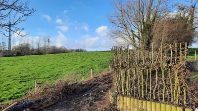 a fence in a field next to a green field at The Kettle House - Manor in Sint-Pieters-Leeuw