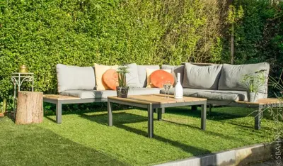 a couch and two tables in a yard at Le Petit Chalet avec hottub. in Sint-Gillis-Waas