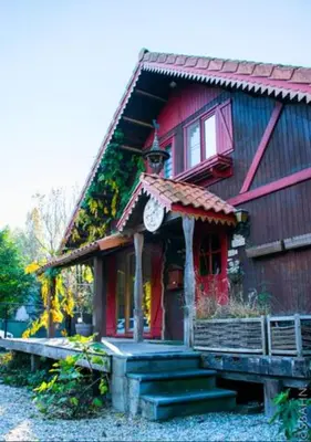a house with a clock on the front of it at Le Petit Chalet avec hottub. in Sint-Gillis-Waas
