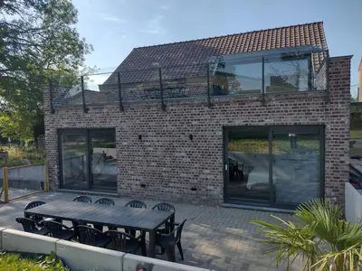 a brick building with a picnic table and chairs at The Kettle House - Stable in Sint-Pieters-Leeuw