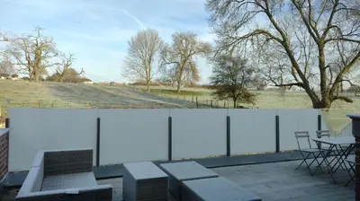 two images of a patio with a table and a field at The Kettle House - Stable in Sint-Pieters-Leeuw