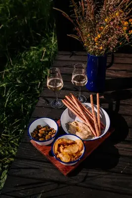 a table with plates of food and glasses of wine at Kalmdown Cabin - Antwerp in Wuustwezel