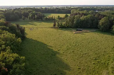 an overhead view of a large field with trees and a barn at Kalmdown Cabin - Antwerp in Wuustwezel