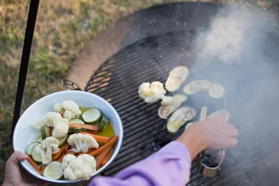 a person holding a bowl of food on a grill at Kalmdown Cabin - Antwerp in Wuustwezel