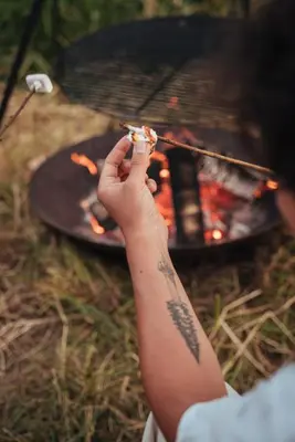 a person holding a piece of food in front of a grill at Kalmdown Cabin - Antwerp in Wuustwezel