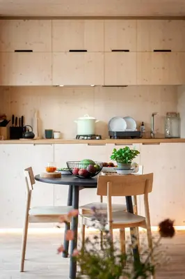 a kitchen with a table and two chairs and a counter at Kalmdown Cabin - Antwerp in Wuustwezel