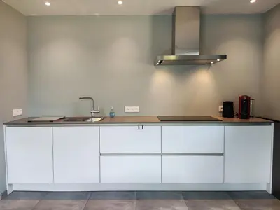 a kitchen with white cabinets and a sink at Gasthuis Puytvoet in Sint-Niklaas