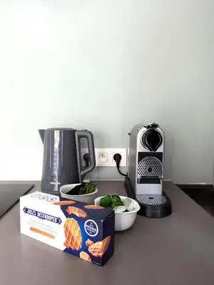 a counter with a box of food and a coffee maker at Gasthuis Puytvoet in Sint-Niklaas