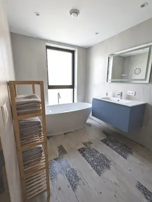 a bathroom with a tub and a sink and a mirror at Gasthuis Puytvoet in Sint-Niklaas