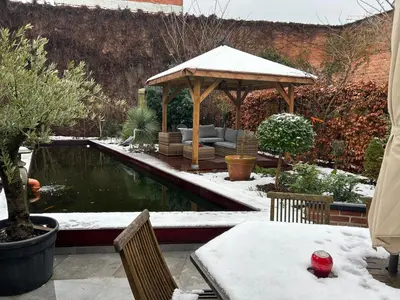 a garden with a gazebo in the snow at Freetimeflat Mies & Fien in Ghent