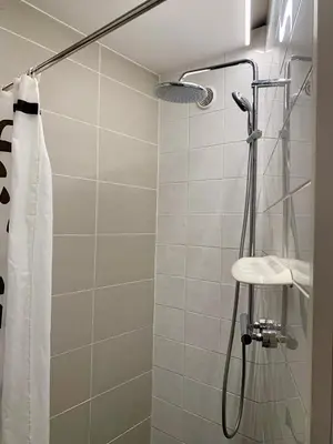a bathroom with a shower with a sink and a shower curtain at Freetimeflat Mies & Fien in Ghent