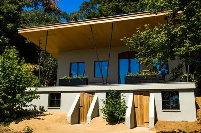 a house with wooden doors and windows at The cabin Morris in Holsbeek