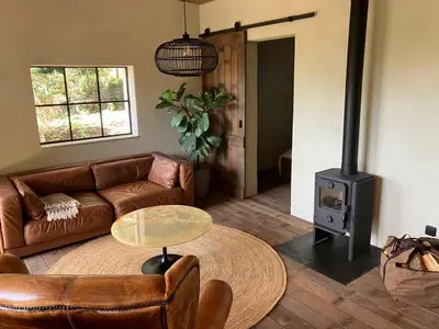 a living room with a couch and a wood stove at The cabin Morris in Holsbeek
