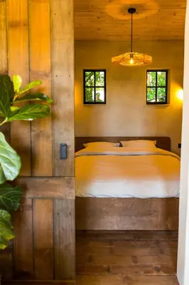 a bedroom with a bed in a wooden wall at The cabin Morris in Holsbeek